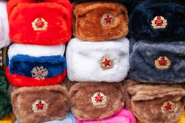 Moskova caddesindeki hediyelik eşya dükkanında kırmızı yıldızlı kulaklıklar. Kış şapkaları, Sovyet ve Rus askeri üniformaları, Rusya 'ya seyahat, turist hediyeleri..