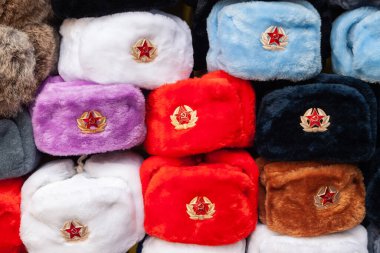 Earflaps fur caps with red stars in souvenir shop in Moscow street. Winter hats, soviet and russian military uniform, travelling to Russia, tourist gifts. clipart