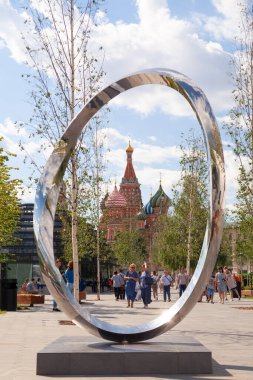 Rusya Moskova 2019-06-17 Yazdan itibaren Zaryadye parkından St. Basils Katedrali 'ne kadar heykel boyunca sonsuz eğri ve yürüyen insanlar. Mimari ve Moskova manzarası. Dikey.
