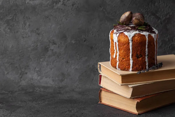 Kulich baked Easter cake stands on books