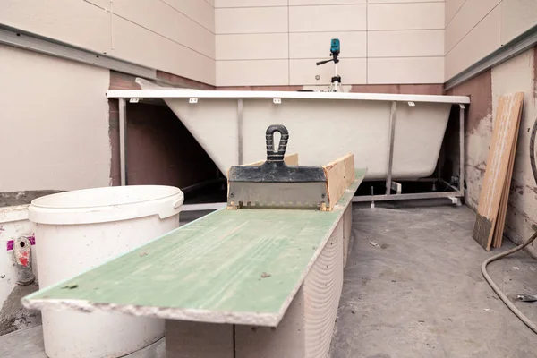 Banyo içi, macun bıçağı, kirli kova, seramik fayanslar.