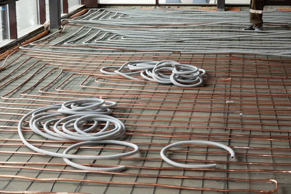 Bent novos tubos de cobre que colocam no chão de concreto — Fotografia de Stock
