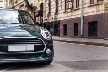Rusya Moskova 2019-06-17 yeşil araba Mini Cooper bir Avrupa şehrinin caddesinde park halinde. Avrupa 'da konsept seyahatler kompleks modayla yapılır.