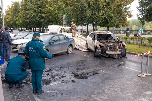 Kemerovo 2019-09-16 serviços policiais fazem inspeção de carro branco abandonado Infiniti FX50S queimado — Fotografia de Stock