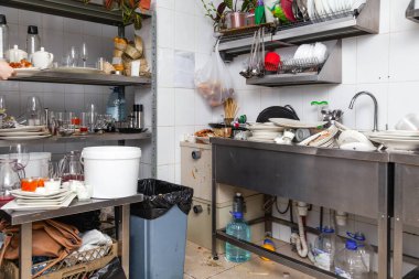 Mutfak kirli bulaşık, çanak çömlek, sofra takımı ile dolu.