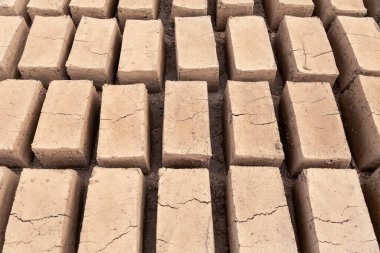 Geleneksel ev yapımı çiğ kil tuğla, tuğla fabrikasında kurutulmak üzere istiflenmiş.