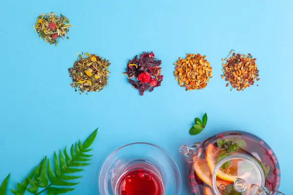 Fruit tea in teapot and tea in cup, piles of different tea — Stock Photo, Image