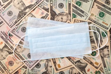 Dolar banknotları üzerinde mavi tıbbi koruyucu maske arka plan, konsept küresel mali kriz