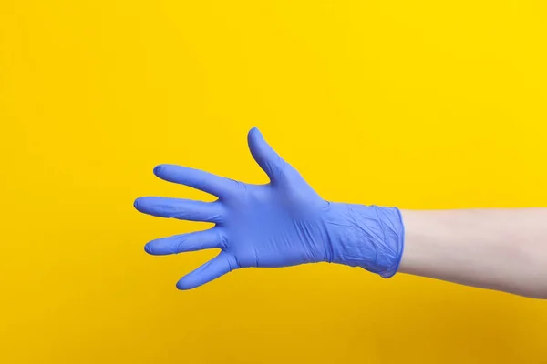 Médico mão em luva de borracha lilás médica mostrando palma, cinco dedos — Fotografia de Stock