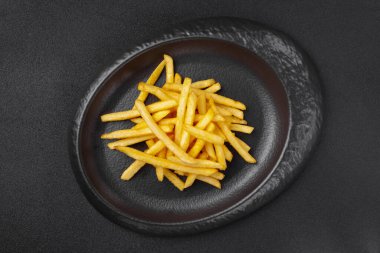 Gri tabakta bir porsiyon patates kızartması.