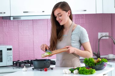 Kadın mutfakta taze olgun sebzelerden yemek pişiriyor. Temiz yemek ve sağlıklı yaşam tarzı. 