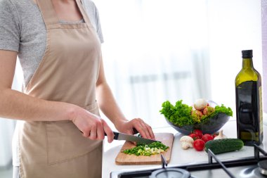 Evde sebze tabakları ve taze salatalar için olgun sebzeleri doğramak. Akşam yemeği için yemek hazırlığı. Temiz, sağlıklı yiyecekler ve düzgün beslenme. Diyet