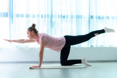 Spor yapan genç bir kadın spor yapıyor ve evde egzersiz yapıyor. Kilo ver ve formda kal. Sağlıklı yaşam tarzı 