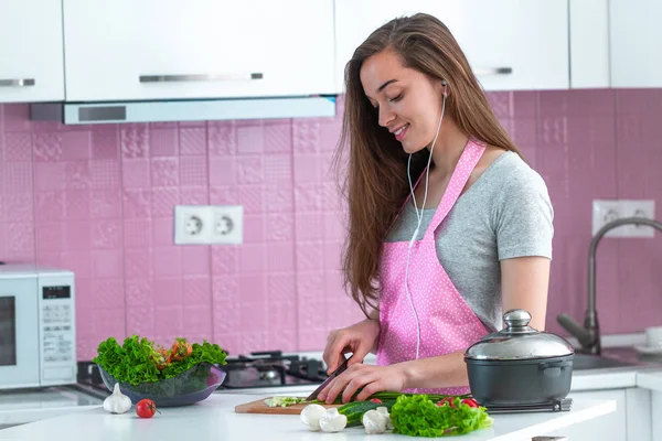 Jonge Huisvrouw Koptelefoon Een Schort Luisteren Muziek Genieten Van Koken — Stockfoto