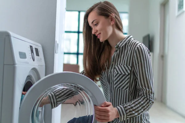 Evde Çamaşır Makinesine Çamaşır Yükleyen Mutlu Çekici Genç Bir Kadın — Stok fotoğraf