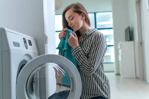 Güzel Genç Bir Kadın Temiz Havlunun Kokusunu Alıyor Evde Çamaşır — Stok fotoğraf