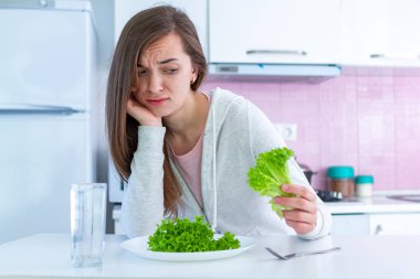 Üzgün mutsuz kadın diyet yapmaktan ve organik, temiz, sağlıklı diyet yemek istememekten bıktı.