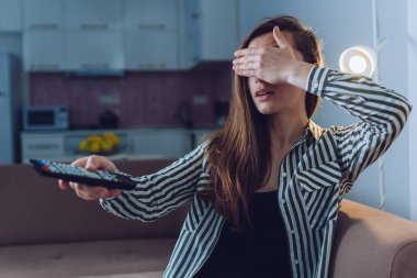 Evde tek başına televizyon izlerken şok olmuş, şaşırmış bir kadın yetişkin, yasak içerik ve sansür görmüş.