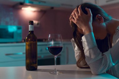 Mutsuz, yalnız, kırmızı şaraplı genç bir kadın akşamları evde tek başına içiyor. Hayat zorlukları ve sorunlar. Kadın alkolizmi ve alkol bağımlılığı