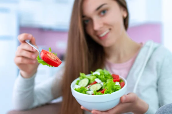Portrait of smiling happy healthy woman eating fresh vegetable salad at home. Balanced diet and fitness eating. Clean and control food