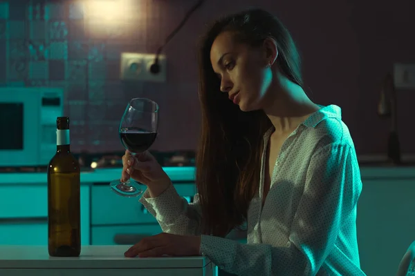 不幸な 赤ワインのガラスとブラウスで悲しい美しい若い女性は家で夜に一人で飲んでいます 人生の問題と困難 — ストック写真