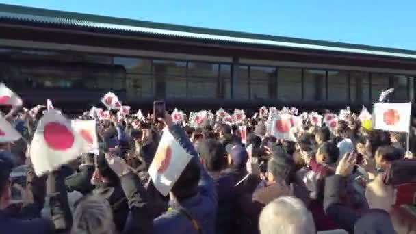 Wideo z pojawienia się cesarza i cesarzowej Japonii na balkonie Sali Chowa-Den Cesarskiego Pałacu Tokio, aby powitać gości, którzy machają japońskimi flagami. — Wideo stockowe