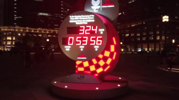 Video der offiziellen Omega-Countdown-Uhr für die Olympischen und Paralympischen Spiele Tokio 2020 vor dem Tokioter Bahnhof in der Nacht. — Stockvideo