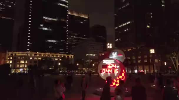 Video del cronometrador olímpico oficial Omega reloj de cuenta regresiva para los Juegos Olímpicos y Paralímpicos de Tokio 2020 frente a la estación de Tokio por la noche . — Vídeo de stock