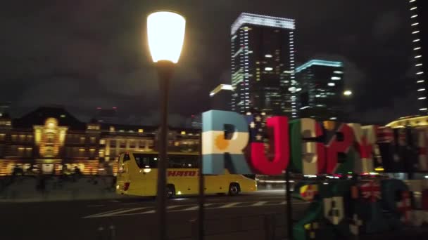 Tokyo, Japón - 06 de octubre de 2019: Vídeo de un enorme monumento tipográfico donde está inscrito RUGBY WORLD CUP 2019 JAPÓN frente a la estación de Tokio por la noche . — Vídeo de stock