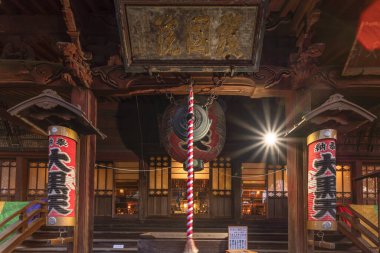 Tokyo 'nun Ueno bölgesindeki Tendai Budizm Tapınağı' nda bulunan Yanaka Yedi Tanrı 'dan birinin kırmızı fener ve waniguchi gonguyla süslenmiş giriş..