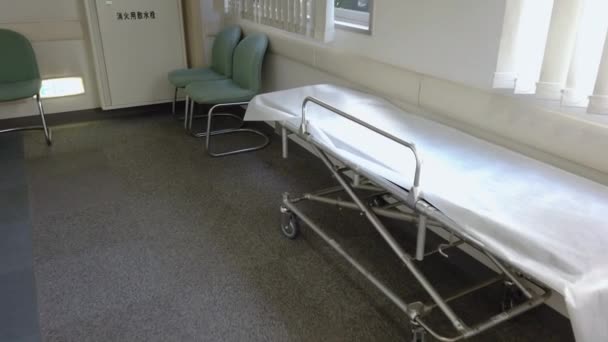 Video of an empty metal stretcher with a white sheet in the corridor of a Japanese hospital in Tokyo. — Stock Video