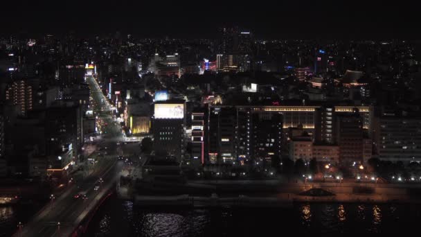 Magas szögű éjszakai statikus videó a Sumida folyóról és a Sensoji templomról Asakusa kerületben, Tokió, Japán. — Stock videók