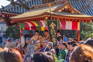 Tokyo, Japonya - 18 Mart 2020: Matsuri-bayashi müzik müzisyenlerinin geleneksel altın ejder dans festivali sırasında davul, fue flüt ve shamisen çaldıkları Budist tapınağının çatısına bakan Yatai arabası