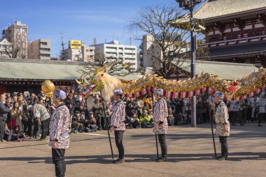 Tokyo, Japonya - 18 Mart 2020: Japon kukla ustaları Asakusa Sensoji Tapınağı 'ndaki Bodhisattva Kannon' a adanmış geleneksel dans festivali için dev bir altın ejderha tutuyorlar..