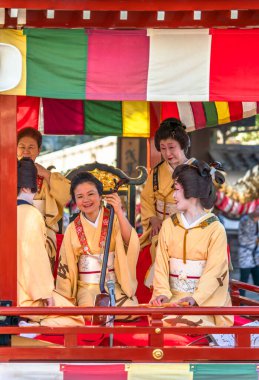 Tokyo, Japonya - 18 Mart 2020: Matsuri-bayashi müzik müzisyenlerinin geleneksel altın ejder dans festivali sırasında davul, fue flüt ve shamisen çaldıkları Budist tapınağının çatısına bakan Yatai arabası