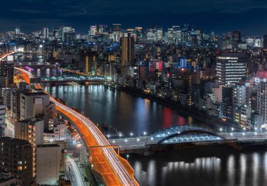 Sumida nehri köprüleri ve geçitleri Tokyo 'nun gökdelenleriyle aydınlanıyor..