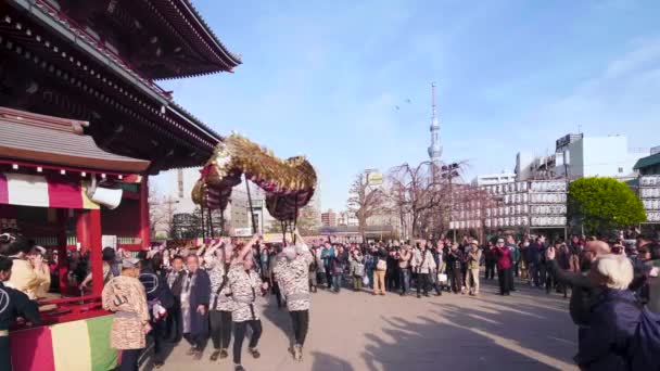 Статическое видео тележки, в которой сидят японские музыканты, играющие во время танца золотого дракона в Асакусе . — стоковое видео