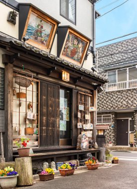 Tokyo, Japonya - 30 Mart 2020: Showa döneminden kalma geleneksel Japon ahşap evleri, Yanaka Ginza ilçesinin sessiz nostaljik ve eski kasaba mahallesinde eski moda restoranlara dönüştürüldü ve dini Ema plaklarıyla süslendi..