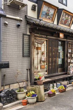 Tokyo, Japonya - 30 Mart 2020: Showa döneminden kalma geleneksel Japon ahşap evleri, Yanaka Ginza ilçesinin sessiz nostaljik ve eski kasaba mahallesinde eski moda restoranlara dönüştürüldü ve dini Ema plaklarıyla süslendi..