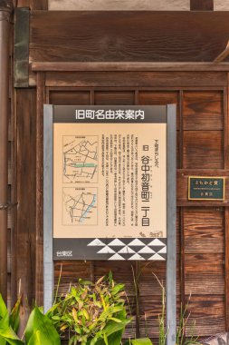 Tokyo, Japonya - 30 Mart 2020: Tokyo 'daki eski içki dükkanının Korinsha sergisi önündeki Yanaka bölgesinde eski kasaba adı Hatsunecho için pano.