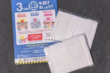 Tokyo, Japonya - 20 Mayıs 2020: Kumaş maskeler ve Japon Abe Shinzo valisi tarafından kronik kıtlıkla başa çıkmak ve koronavirüsün yayılması ile savaşmak için gönderilen sosyal mesafeyi destekleyen broşür (COVID-19).