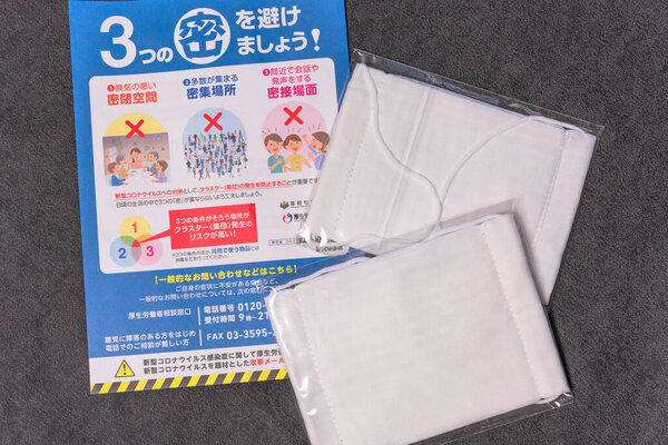 tokyo, japan - may 20 2020: Cloth masks and leaflet promoting social distancing sent by Japanese govt of Abe Shinzo to cope with the chronic shortage and fight the spread of coronavirus (COVID-19).