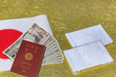 Tokyo, Japonya - 20 Mayıs 2020: Japon hükümeti tarafından Coronavirus (COVID-19) ile savaşmak için gönderilen kumaş maskeler ve 100.000 yen nakit para ve Japonya bayrağı ve altın kağıt üzerinde pasaportlu işsizlik.