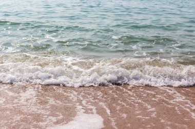Kumsalda beyaz deniz dalgaları kabarcığı