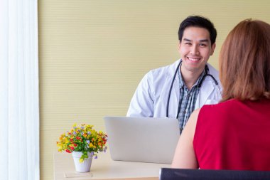 Doktor Asyalı kadın hastaların semptomlarını sorguluyor. Bir dahaki sefere modern tıpla tedavi için kolunun kırılmasıyla ilgili..