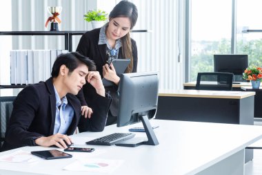 Bilgisayarlar ve beyin fırtınası yoluyla bilgi analiz eden genç iş adamları finansal veriler hakkında ciddi ve mutsuz hissediyorlar. Modern ofisteki performansı analiz etmek için bir iş raporu getir.