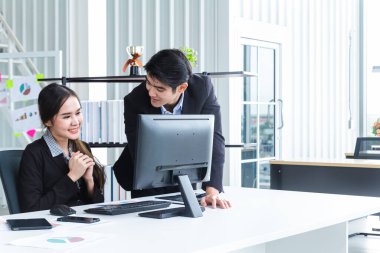 Bilgisayarlar ve beyin fırtınası yoluyla bilgi analiz eden genç iş adamları finansal veriler konusunda başarılı oldukları için mutlular. Modern ofisteki performansı analiz etmek için bir iş raporu getir.