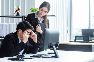Bilgisayarlar ve beyin fırtınası yoluyla bilgi analiz eden genç iş adamları finansal veriler hakkında ciddi ve mutsuz hissediyorlar. Modern ofisteki performansı analiz etmek için bir iş raporu getir.