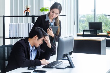 Bilgisayarlar ve beyin fırtınası yoluyla bilgi analiz eden genç iş adamları finansal veriler hakkında ciddi ve mutsuz hissediyorlar. Modern ofisteki performansı analiz etmek için bir iş raporu getir.