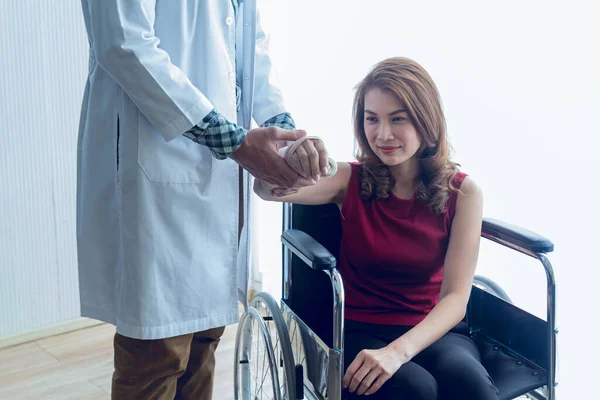 Asyalı bir kadın hasta kolunu kırarak bir kaza geçirdi ve tekerlekli sandalyeye mahkum oldu. Uzmanlık alanı bir atel olan bir doktor tarafından tedavi gördü..